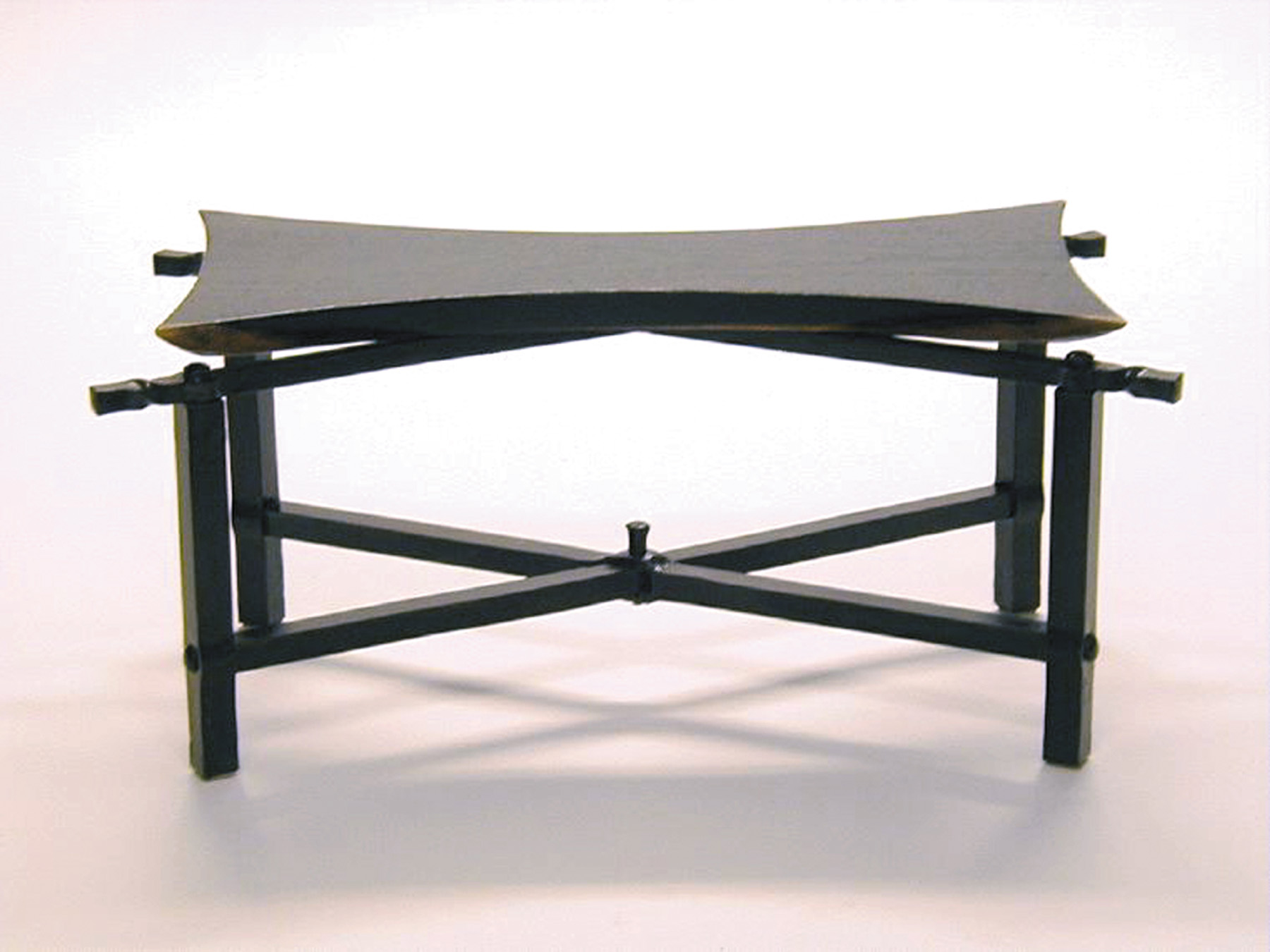 Contemporary table built with wenge and forged steel. The wenge tabletop is shaped like a japanese butterfly. The steel base has traditional blacksmith details, including hammered texture and twisted steel.