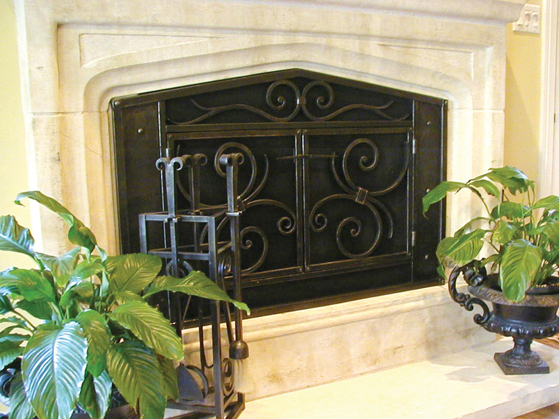 Fireplace screen built with forged steel. Features forged scrolls and hammered texture and double doors and a custom door latch. Very traditional design but very custom by Ironwood Industries.