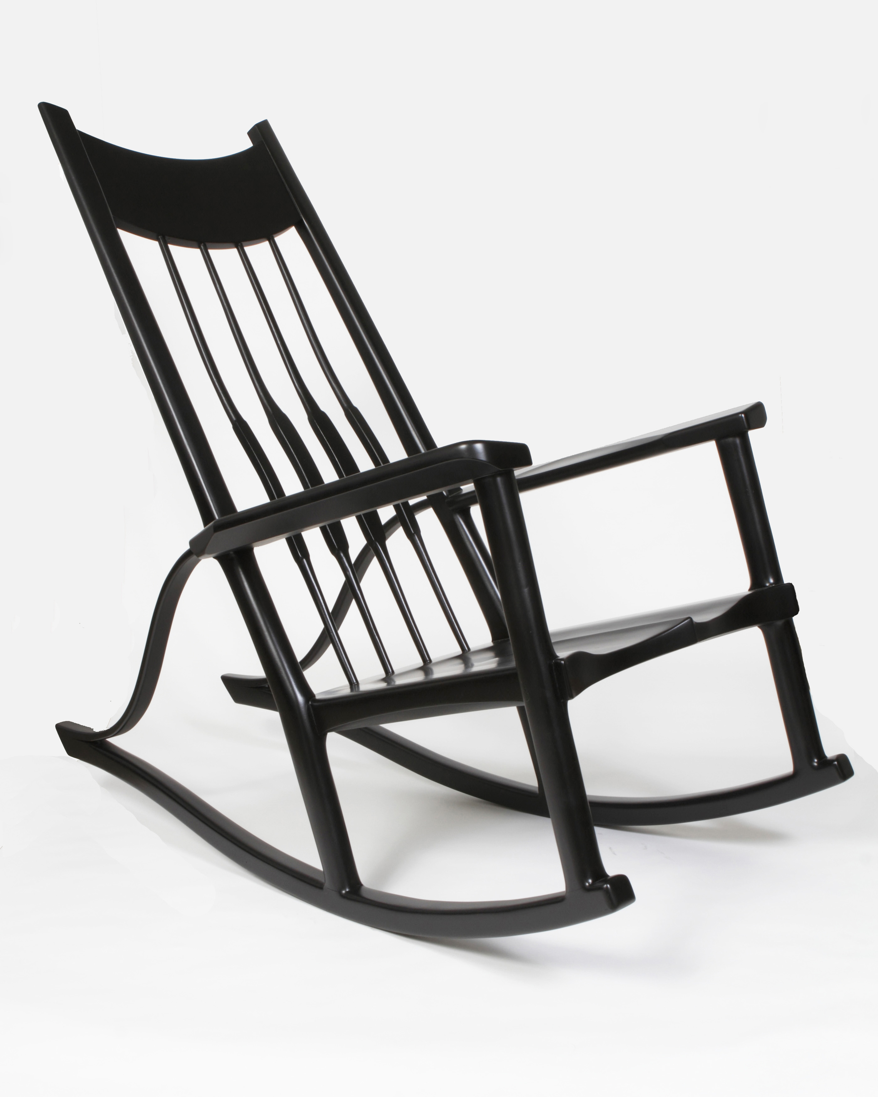 Contemporary rocking chair built with pecan. Rocking chair has a sculpted seat, high backrest, and sculpted armrests. Also features bent-laminated supports that connect the rockers to the armrests, making it look like a musical instrument. The texas pecan is painted with black lacquer.